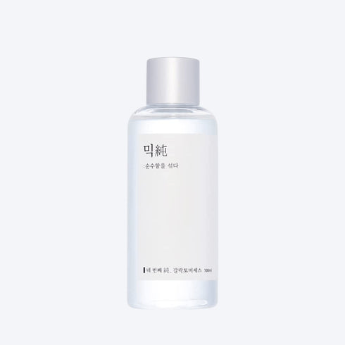 MIXSOON Galactomyces Ferment Essence Imaginea înfățișează o mână care ține cu grijă o sticlă de Mixsoon's Beta-Glucan Face Essence. Acest produs este o dovadă a angajamentului mărcii față de minimalism și eficacitate. Flaconul transparent și eticheta curată a esenței reflectă puritatea și simplitatea formulei din interior